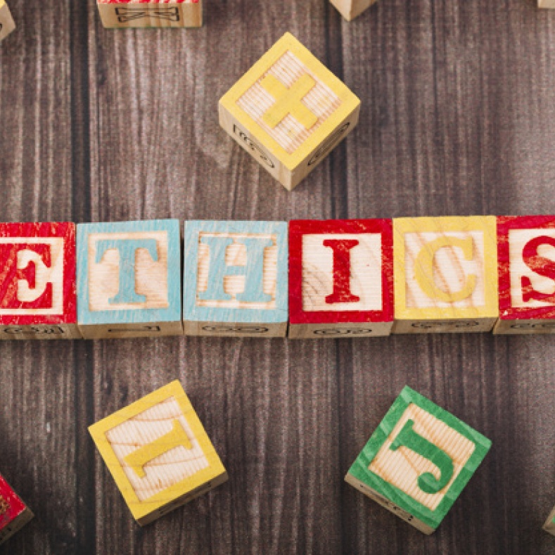 Wooden building blocks with wooden letters, put together to make Ethics